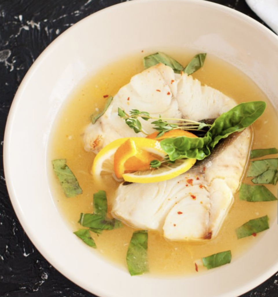 dos de cabillaud cuit à la vapeur, bouillon doré, citron et basilic en assiette creuse