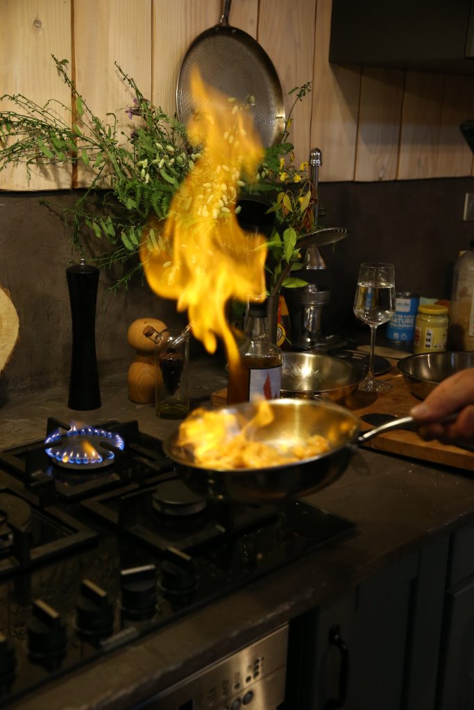 wok en inox sur induction avec des légumes sautés en pleine cuisson