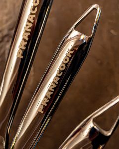 Poingée en inox avec logo pranacook, lumières chaudes et béton ciré en arrière plan