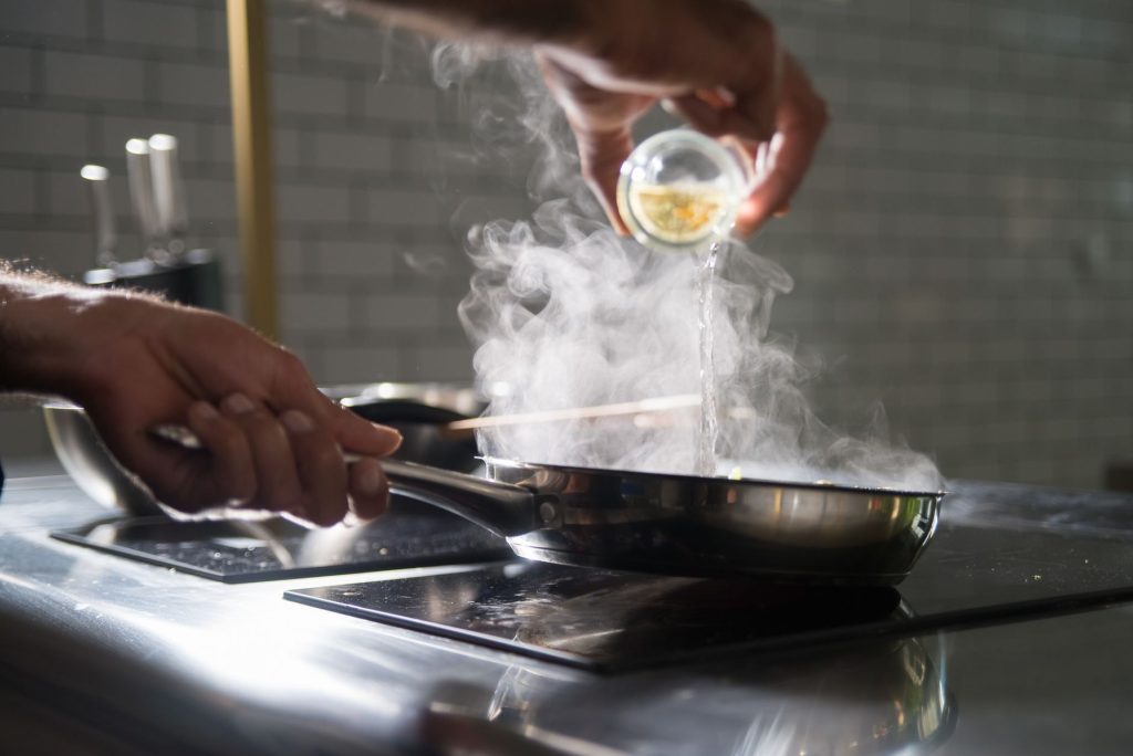 a person cooking using frying pan